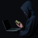 The concept of cyber theft. Hackers holding gold smart cards and hacker